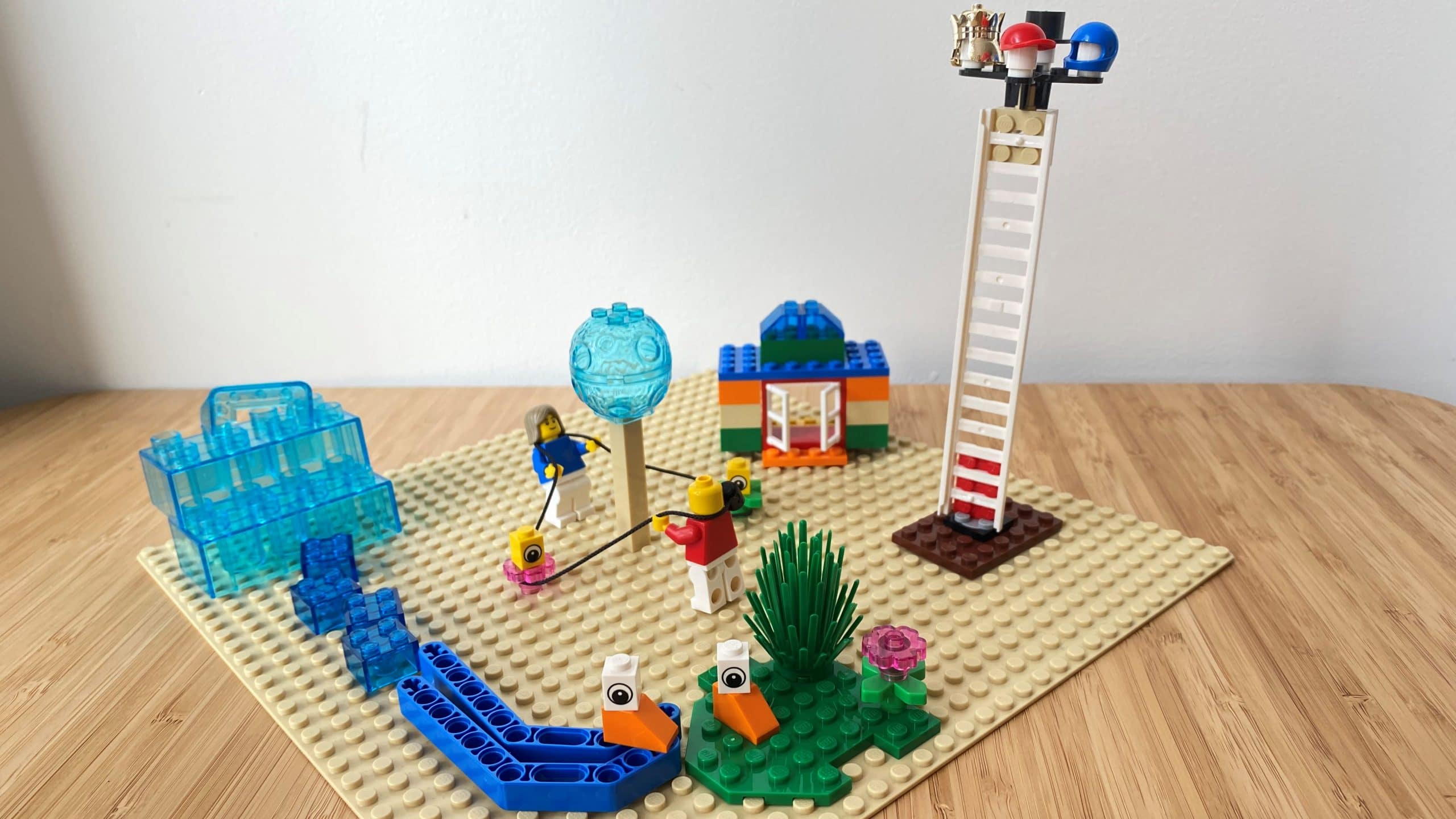 A LEGO Serious Play build showing various elements. The baseplate is lying on a timber desk with a white wall behind.